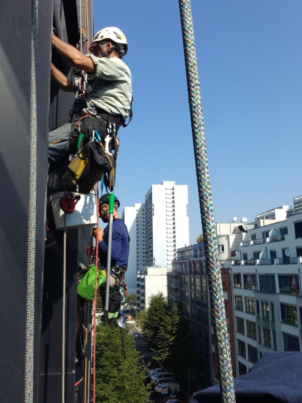 Two technicians descending a building facade