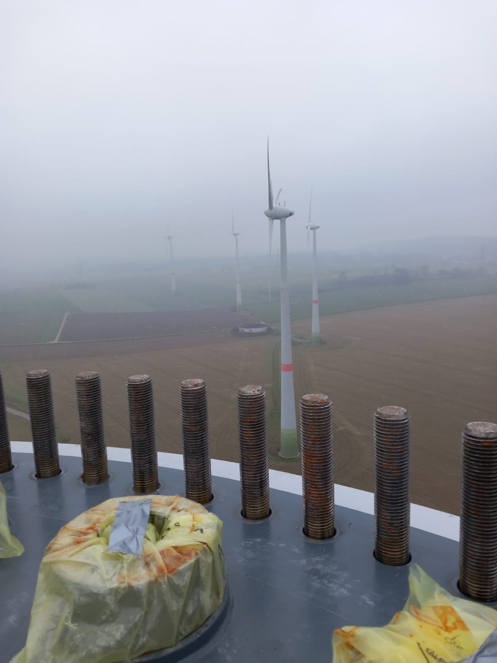 Foggy view of a wind farm from a turbine hub