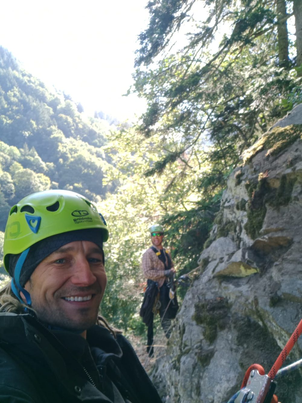 Two climbers on a rope access job by a rock face