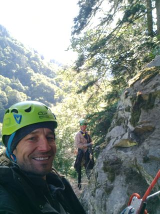 Two climbers on a rope access job by a rock face